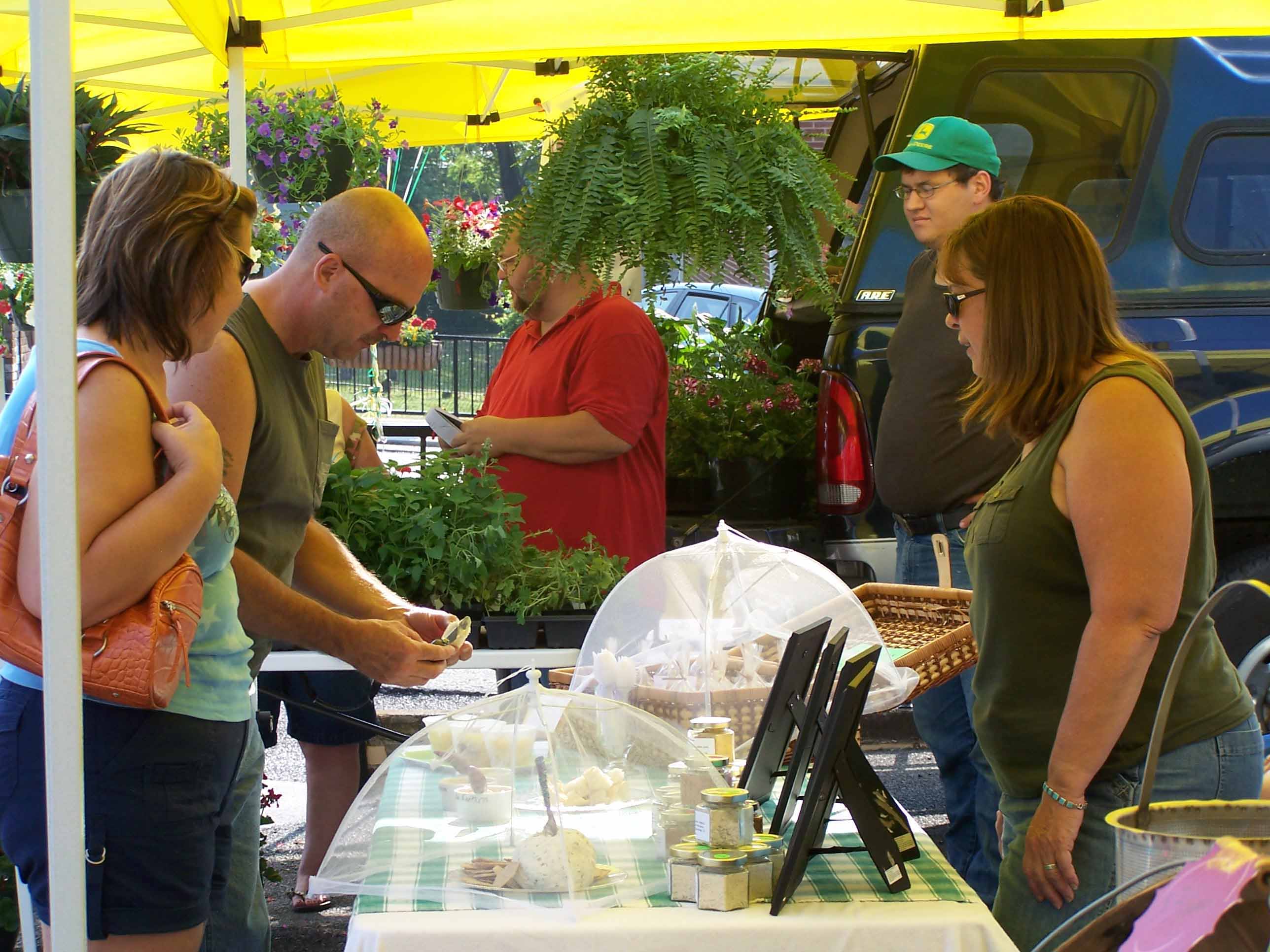 People enjoying a craft booth at the downtown Dandridge Farmers Market.