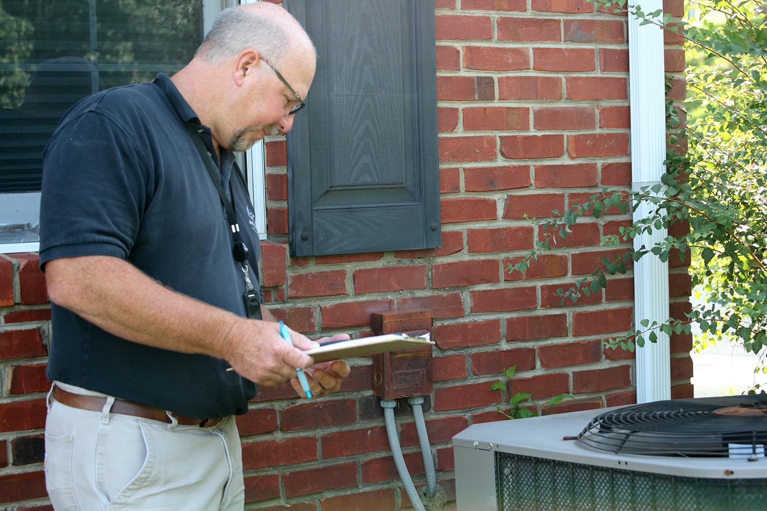 AEC tech performing a heat pump inspection