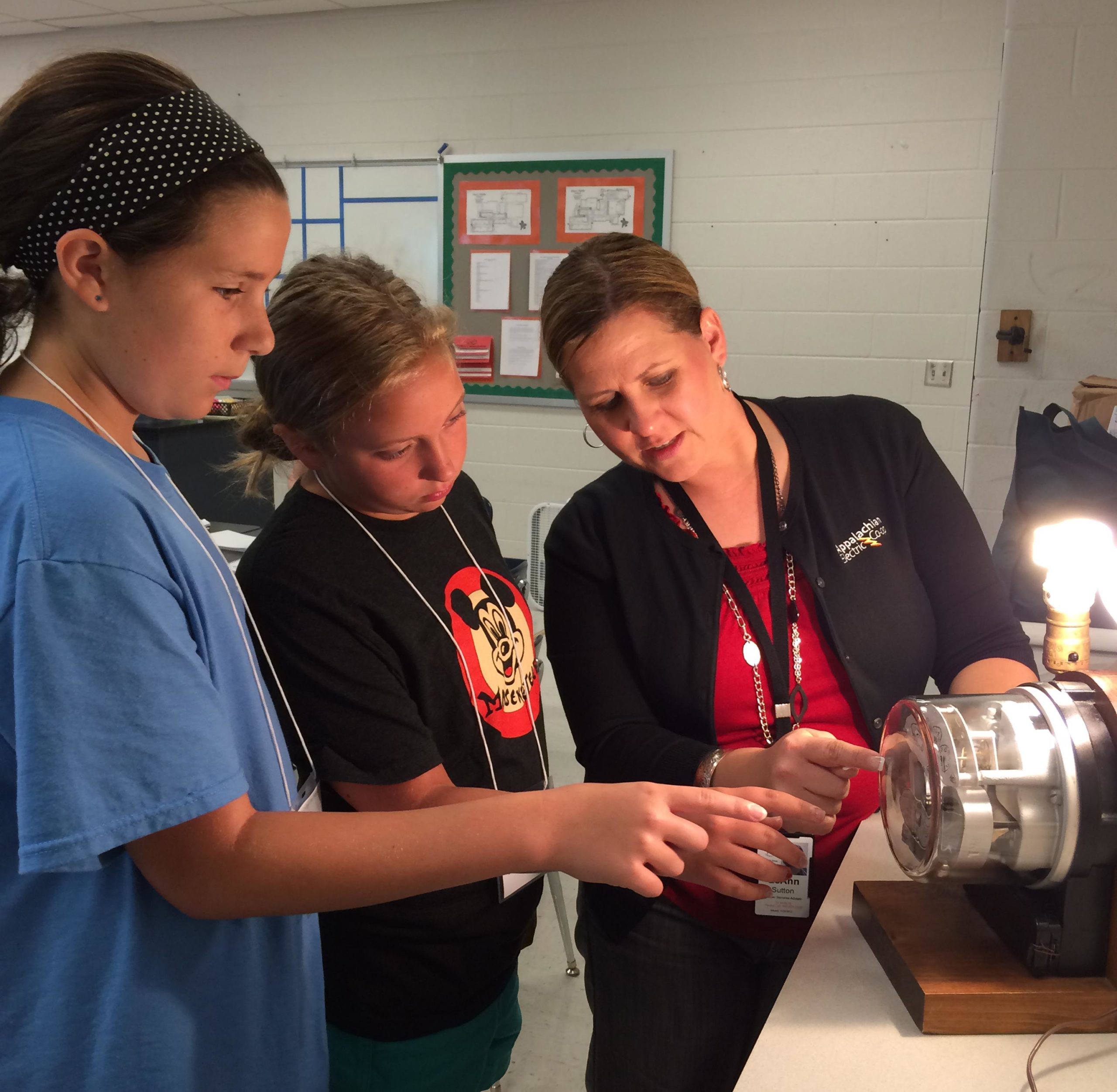 AEC employee showing two stem academy students something