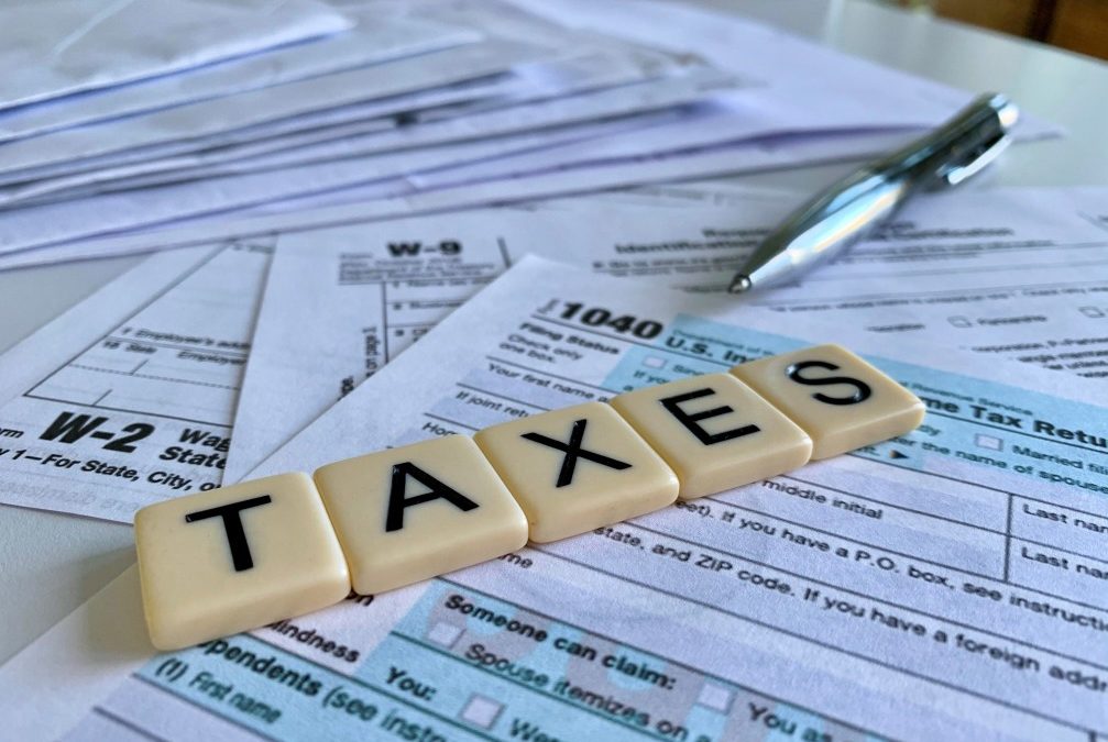 letters spelling out taxes on top of a bunch of tax forms